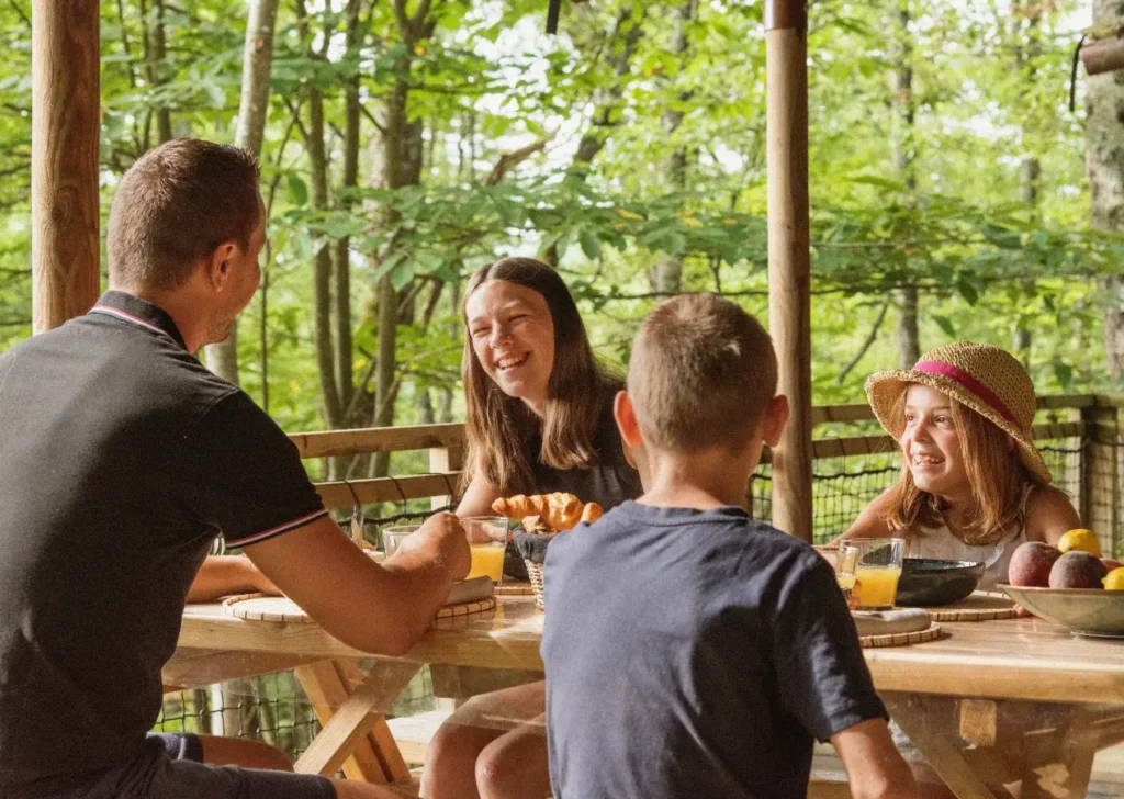Petit déjeuné en famille sur terrasse d'un mobile home en pleine nature